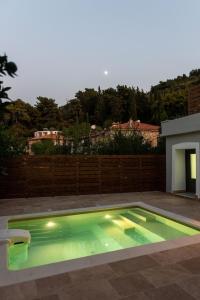 萨摩斯Villa Samos - Renovated stone villa with private pool- 2 min from the sea!的后院的绿色灯光游泳池