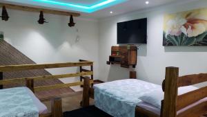 纳韦甘蒂斯Hospedagem 3 Estrelas的客房设有两张床和一台墙上的电视。