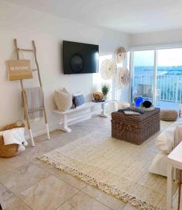 基克罗尼海滩Your Happy Place ON THE BEACH!的客厅配有沙发和墙上的电视