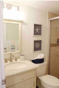 基克罗尼海滩Your Happy Place ON THE BEACH!的白色的浴室设有水槽和卫生间。