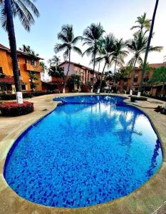 Boca de AroaVilla Vacacionales Los Cayos Con Playa Privada的一个种有棕榈树的大型蓝色游泳池