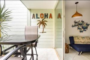 科纳DOWNTOWN LOCATION! Hawaiian Theme Condo with Hot Tub, Pool & Beach的一间带桌子和蓝椅的用餐室