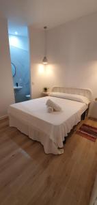 甘迪亚Alójate Gandia Ermita的铺有木地板的客房内一张大白色的床