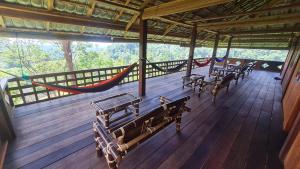 武吉拉旺武吉拉旺山地度假酒店的木甲板上配有长椅和吊床的门廊