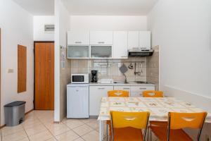 伊齐齐Apartment Igor的一间厨房,里面配有桌子和黄色椅子