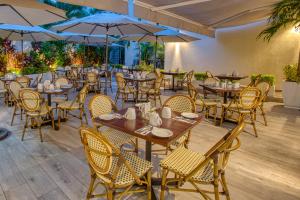 巴亚尔塔港Casa Nicole Boutique Hotel的餐厅设有木桌、椅子和遮阳伞