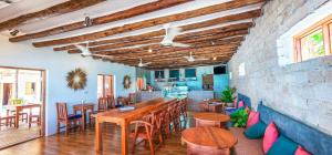 帕杰Ananda Beach Hotel的一间带木桌和椅子的用餐室