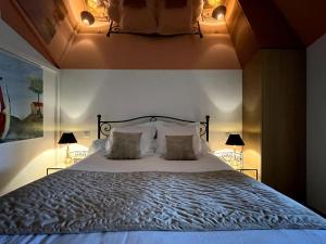 波格尔Gîte de charme 5 étoiles pour couple avec sauna et jacuzzi extérieurs privatifs的一间卧室配有一张大床和两盏灯