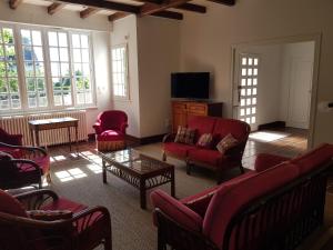 孔卡尔诺Villa sur la corniche vue mer的客厅配有红色椅子和电视