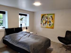 海宁Værelser i midtbyen的卧室配有一张床,墙上挂有绘画作品