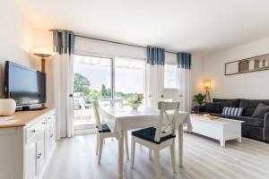 波尔尼克La Terrasse du golf的厨房以及带白色桌椅的起居室。