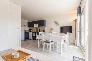 波尔尼克La Terrasse du golf的厨房以及带白色桌椅的用餐室。