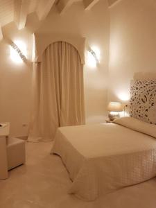 里杜德里伊斯坦西Hotel Azzurra的白色的卧室设有床和窗户