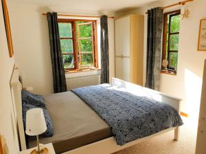 LangballigFerienwohnung Hyggebo的一间卧室设有一张床和两个窗户。
