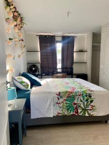 帕皮提Meherio - Bel Appartement vue mer à TAHITI的一间卧室配有一张带彩色毯子的床