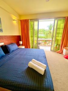 迪古拉Sands Grand Hotel的一间卧室配有蓝色的床和2条毛巾