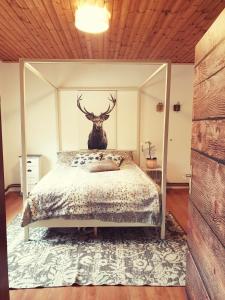 St. MartinDie Alm in Schöllbüchl的卧室配有一张带鹿头的墙壁床。