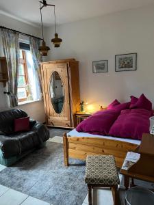 RehdenGästehaus Peerhus Dönsel - Peerknecht的一间卧室配有一张带紫色枕头的大床