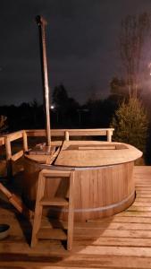 达卡卫Cabañas El Roble的木制热水浴缸,在晚上坐在甲板上