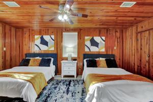 温泉城Lake Haven Cottage On Lake Hamilton的一间卧室配有两张床和吊扇