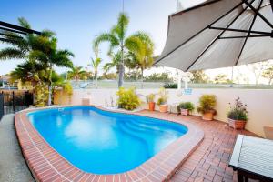 洛坎普顿格伦莫尔塔文旅馆的一个带遮阳伞和棕榈树的游泳池