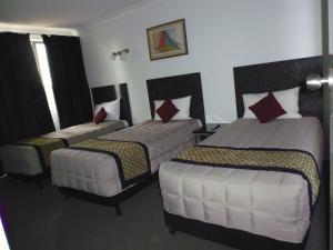 金格罗伊伯克威尔斯汽车旅馆的一间酒店客房,房间内设有三张床
