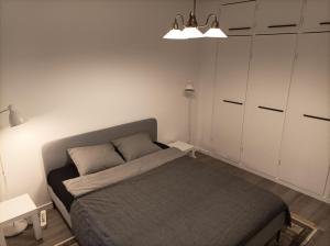 赫尔辛基Ihan Puotilan Metron lähellä的一间小卧室,配有一张床和白色橱柜