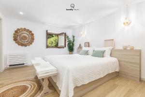 卡米尼亚Casa do Monte Locally Yours的白色卧室设有一张大床和镜子