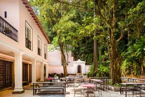 里约热内卢JO&JOE Rio de Janeiro Largo do Boticario的庭院配有桌椅和树木
