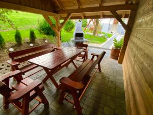 MutneDomek całoroczny "U Haliny''的露台上的木桌和椅子,配有烧烤架