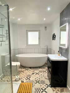 蒙特罗斯Bright 2-bedroom apartment with parking in Montrose的带浴缸、两个盥洗盆和淋浴的浴室。