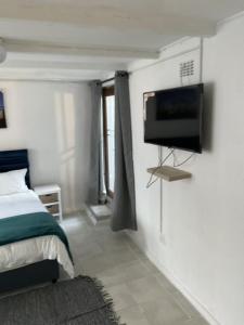 开普敦Cub's Home的卧室配有一张床和壁挂式平面电视。