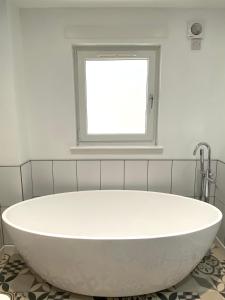 蒙特罗斯Bright 2-bedroom apartment with parking in Montrose的带窗户的浴室内的白色浴缸
