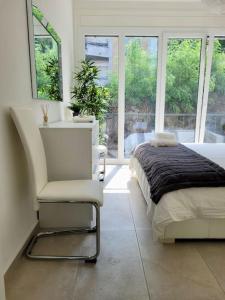 卢加诺Apartment PALMA - Central & Cozy with Free Private Parking的一间卧室配有一张床、一把椅子和窗户。