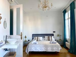 毕尔巴鄂Apartamento en el centro de Bilbao的一间卧室配有一张床、一个水槽和一个吊灯。