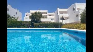 SotograndeUrb Jardines de Sotogrande dúplex, 120 m2, Piscina的大楼前的大型游泳池