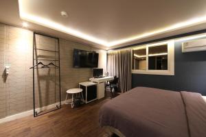 釜山Hotel Frenchcode的一间卧室配有一张床、一个水槽和一台电视
