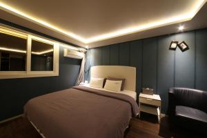 釜山Hotel Frenchcode的一间卧室配有一张大床和一把椅子