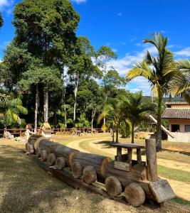 佩德拉阿祖尔Pousada Vista Pedra Azul的公园里的野餐桌和木柴