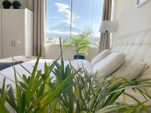 阿雷基帕Furnished Aparments Arequipa的卧室设有白色的床和大窗户