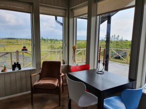 霍尔斯沃德吕尔Adorable cosy and private new cabin in the south的客房设有桌椅和窗户。