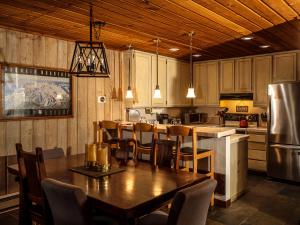 马姆莫斯湖COZY Condo at Canyon Lodge! Sleeps 8, a walk to Canyon Lodge的厨房配有桌椅和冰箱。