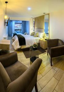 万卡约Hotel Huaytapallana suites的一间卧室设有一张床和一间客厅。