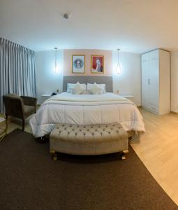 万卡约Hotel Huaytapallana suites的一间卧室配有一张大床和一把椅子