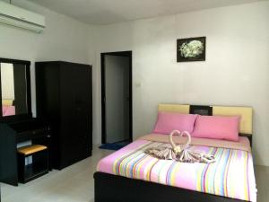 象岛Baansanook Resort & Swimming Pool的一间卧室配有粉红色的床和梳妆台