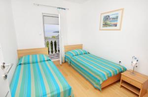 奈维斯Apartments by the sea Njivice, Krk - 5296的一间卧室设有两张床和窗户。
