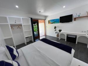 莫阿尔博阿Secret paradise moalboal的卧室配有一张床,墙上配有电视。