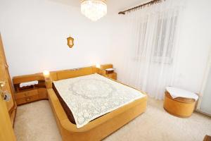 斯姆里卡Apartments with a parking space Smrika, Kraljevica - 5508的一间卧室配有一张床和一个吊灯