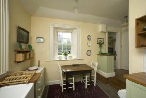 卡波昆Salterbridge Gatelodge的厨房以及带桌子和窗户的用餐室。