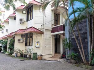 泗水Graha Ara Homestay Syariah RSUD Dr Soetomo Surabaya Mitra RedDoorz的一座棕榈树建筑